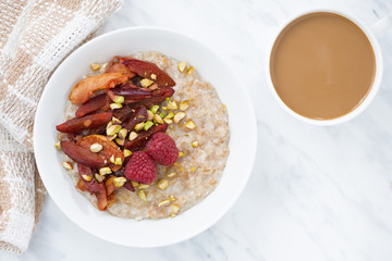 oatmeal with baked fruits and coffee with milk, top view closeup