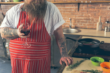 Man drinking wine while cooking