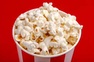 Popcorn in red and white cardboard box. Popcorn border isolated on white. Film. Fast food. Corn