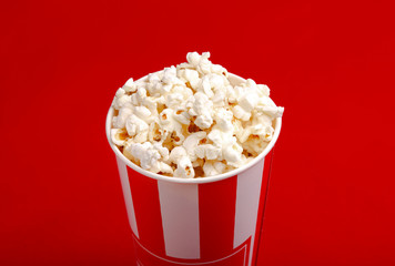 Popcorn in red and white cardboard box. Popcorn border isolated on white. Film. Fast food. Corn