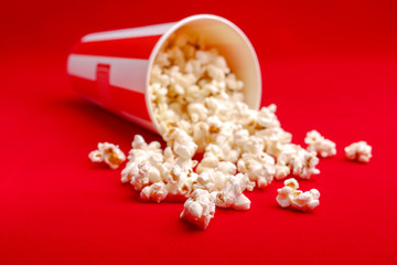 Popcorn in red and white cardboard box. Popcorn border isolated on white. Film. Fast food. Corn