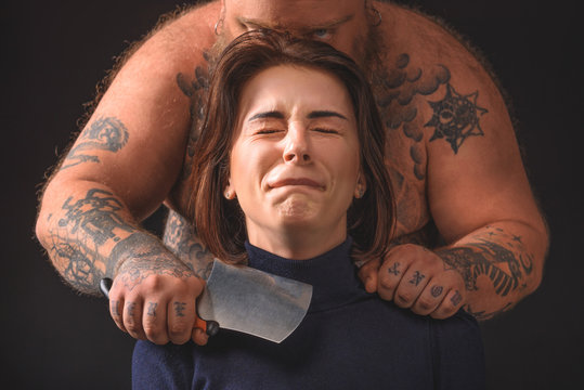 Man standing behind scared woman with a knife to her neck
