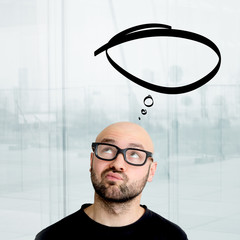 Portrait of an attractive dubious geek man with thinking comics bubble over his head