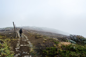 One person hiking to the peak of Mount Kumanodake - Stock image	