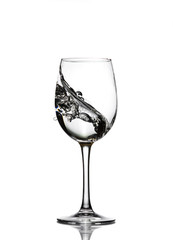 A splash of crystal clear water in a glass for wine. Water splashes. Drinking water. Alcohol.