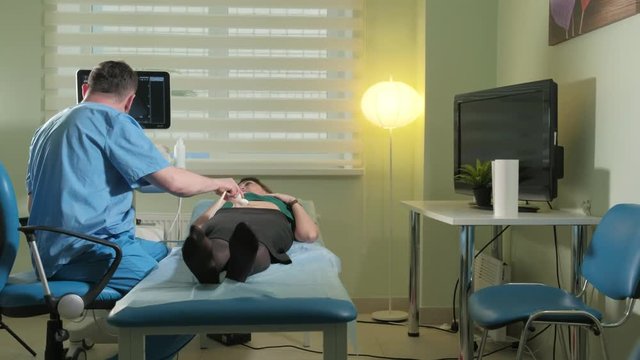 Doctor doing 3d ultrasound on belly of t woman in clinic 4k