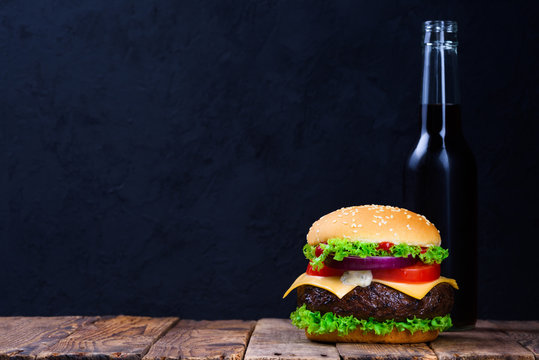 Burger and drink on wooden table with copy space