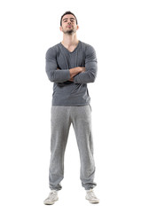 Fototapeta premium Tough proud serious athlete with crossed arms and head tilted back. Full body length portrait isolated on white studio background. 