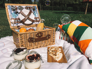 Picnic Basket Food On Blanket With Pillows And Soap Bubbles