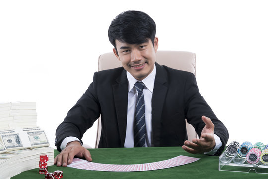 The Young dealer in black suit with gesture inviting and gambling devices on green table