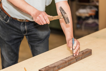 Male hands of builder man holding hammer and scored