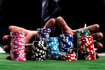 A poker Player hands pushing in all his chips to betting - 150013683