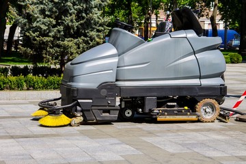 Street sweeper machine cleaning walkways in the park