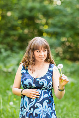 Beautiful pregnant woman relaxing outside in the park