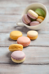 Obraz na płótnie Canvas Colorful French macaroons on wooden background, selective focus, copy space