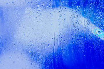 Drops on the glass rain blue background