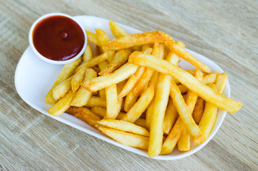 French fries on plate on a wooden background
