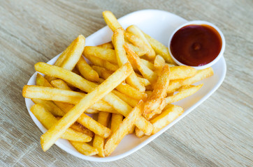 French fries on plate on a wooden background