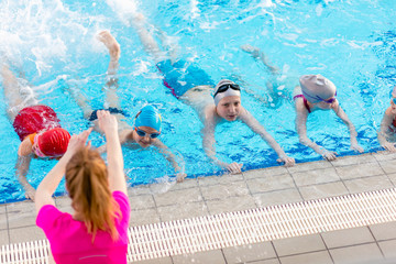 happy children kids group at swimming pool class learning to swim