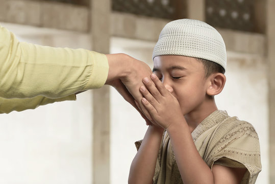 Asian muslim child kissing a hand from an old people