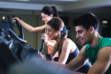 Group of men and woman in training gym doing fitness exercise.