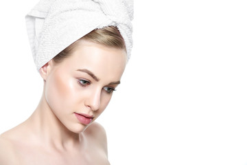 Beautiful Young Blond Woman with Perfect Skin and her hair wrapped in a towel. Cosmetology, beauty and spa concept. Isolated on white background.