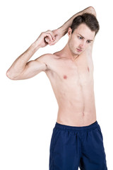 Fototapeta premium Healthy lifestyle. Portrait of a handsome guy with a sporty naked body, warming up, isolated on white background. Vertical frame