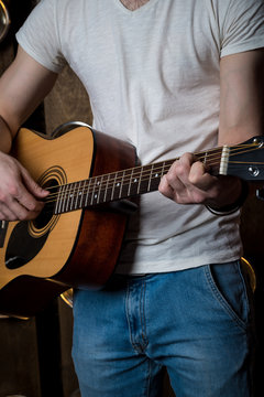 Playing guitar. Acoustic guitar in the hands of the guitarist. Vertical frame