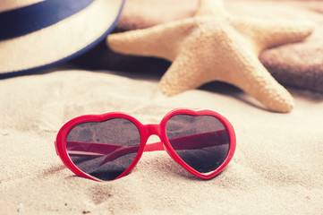 Fototapeta na wymiar Starfish with glasses on a beach sand
