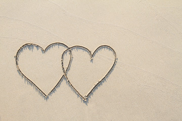 Two hearts on the beach with soft shadow, sending love concept