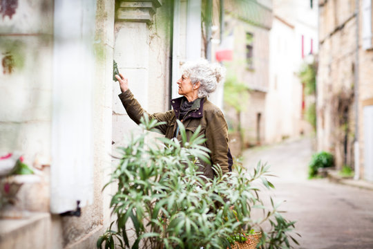 Woman knocking on door, Bruniquel, France