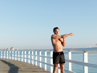 Swimmer stretching on boardwalk, Eastern Beach, Geelong, Victoria, Australia