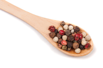 Mixture of peppers hot, red, black, white and green pepper in a wooden spoon isolated on white background. Top view