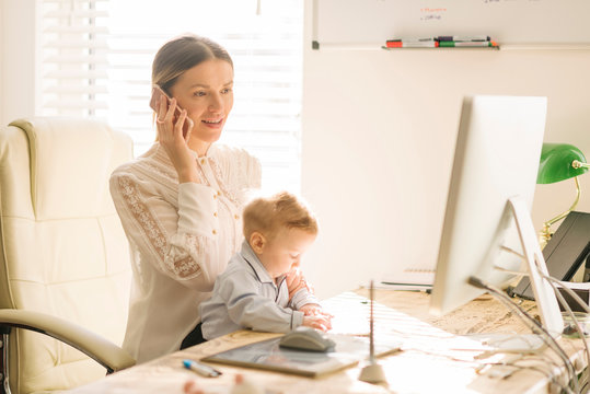 Mother working and caring for baby at home