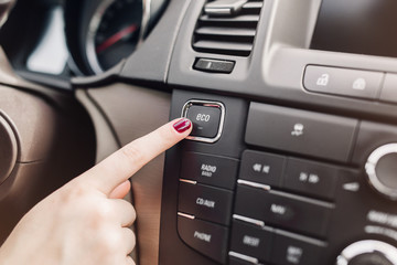 Hand finger press button Eco mode in car,Green concept. transport, modern, green energy, technology...