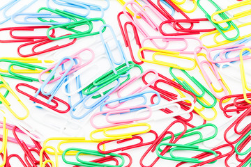 Messy colorful paper clips on white background