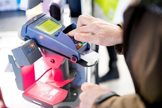Mature woman using credit card machine to pay for shopping, close-up
