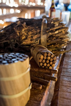 Packages of hand made cuban cigars with tobacco leaves on workbench, Vinales, Cuba