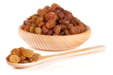 raisins in a wooden bowl with spoon isolated on white background