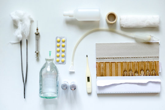 Overhead view of medical equipment and drugs on white background