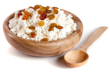 Cottage cheese with raisins in a wooden bowl isolated on a white background