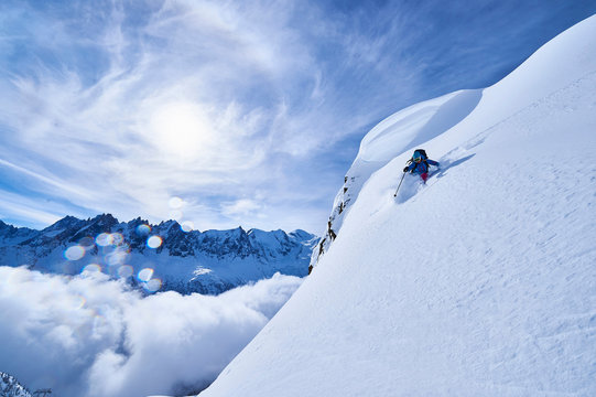 Woman skiing down steep mountainside in Swiss Alps, Gstaad, Switzerland