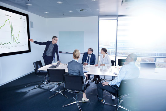 Businessman making flat screen presentation to team in boardroom