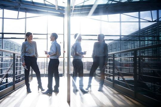 Businessman and woman talking on office balcony