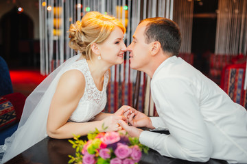 Wedding photo session in interior. Bridal couple, Happy Newlywed woman and man embracing. Romantic wedding.