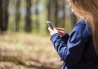 Woman using mobile phone during walk in park