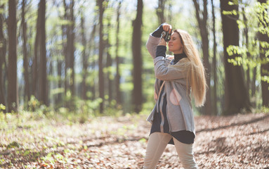 Woman in park taking photos with retro film camera