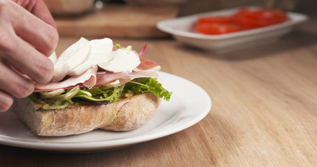 shot of mozzarella put on ciabatta bread preparing sandwich, 4k photo