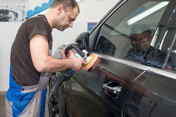 A man polishes a black car