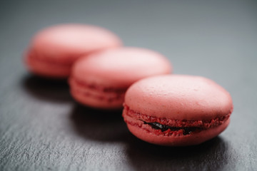 bright pink macarons on slate background, shallow focus